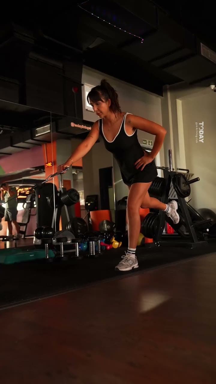Fitness katında kettlebell ve sağlık topuyla fonksiyonel antrenman yapan kadın