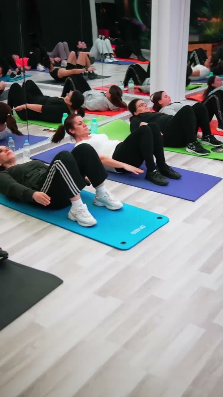 Stüdyoda renkli matlar üzerinde egzersiz yapan grup