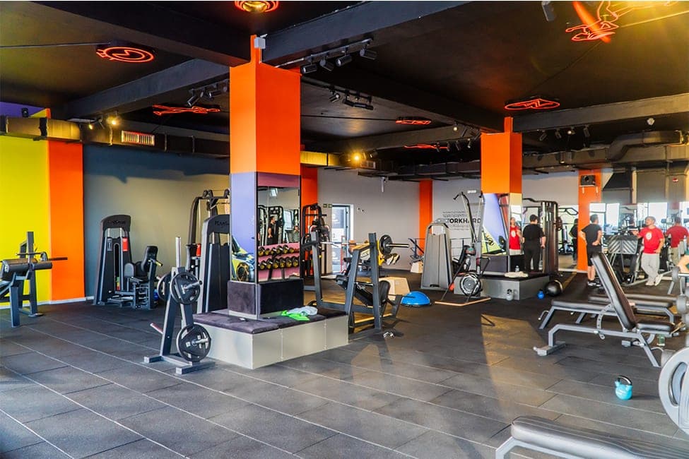 Today Living Club fitness salonu: turuncu kolonlar, siyah tavan ve ağırlık makineleri