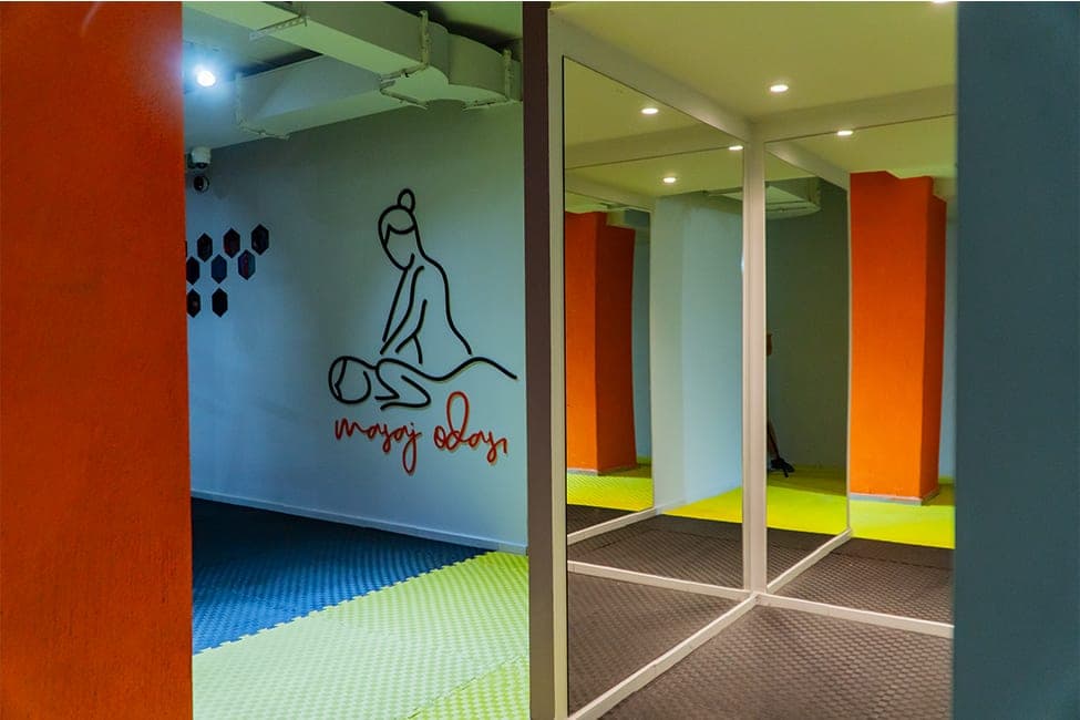Today Living Club masaj odası girişi: duvarda masaj çizimi, “masaj odası” yazısı ve aynalı bölme